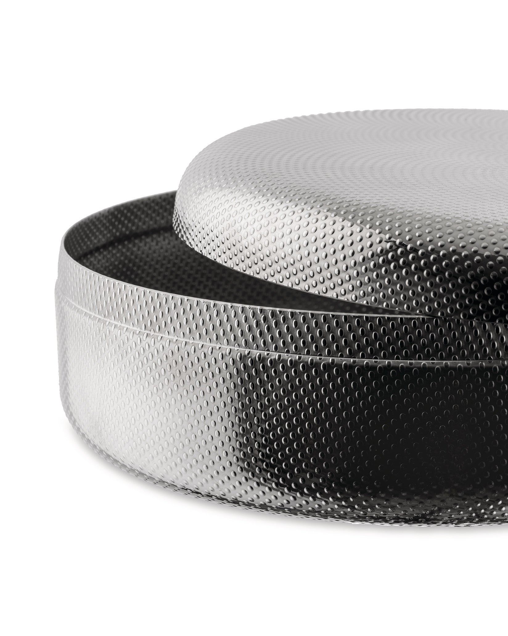 Silver round metal container by Alessi with perforated texture and slightly open lid.