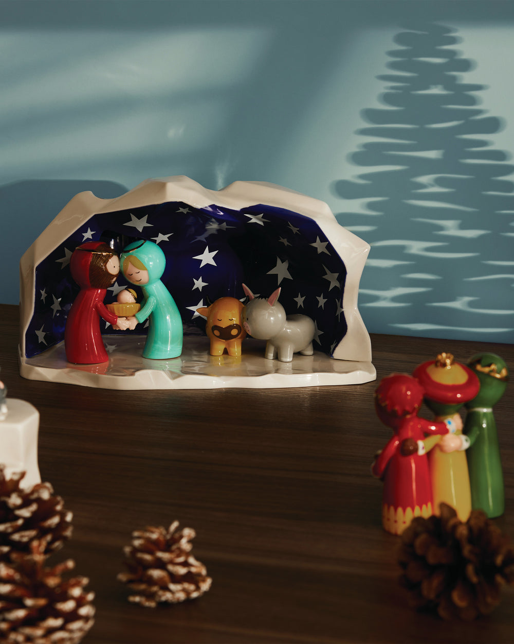 Colorful stylized Happy Eternity Baby nativity set by Alessi, featuring Mary, Joseph, baby, ox, and donkey figures in a starry grotto.